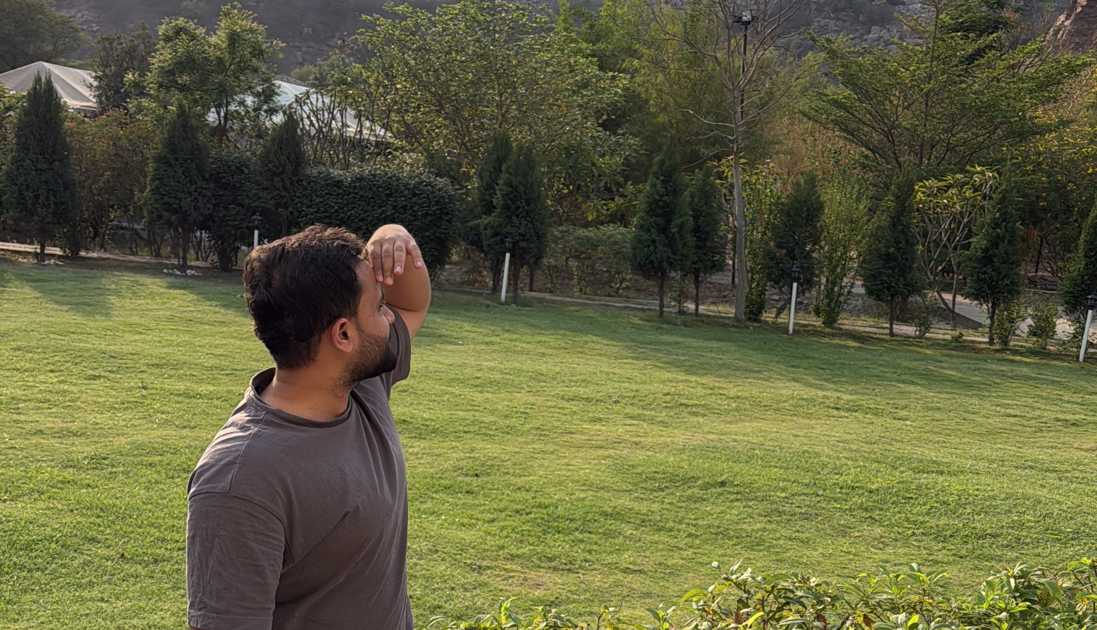 Man shielding eyes, looking at green field during BeatRoute team offsite.